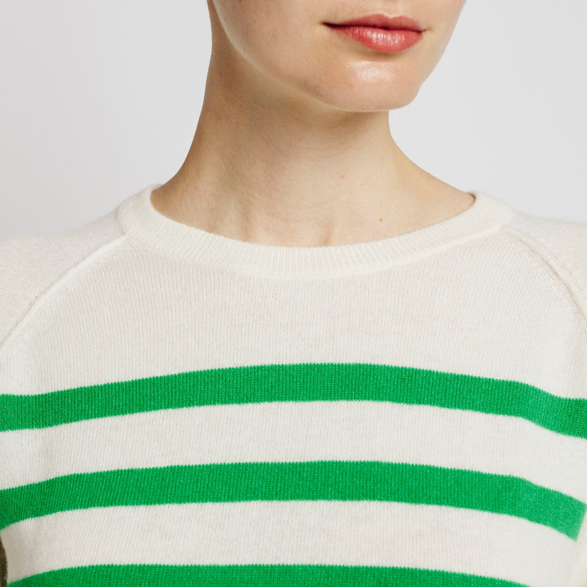 Alabaste Le Breton cashmere sweater in spring green and cream, close-up of neckline and upper chest showing horizontal stripes and raglan seam, 100% Mongolian cashmere.