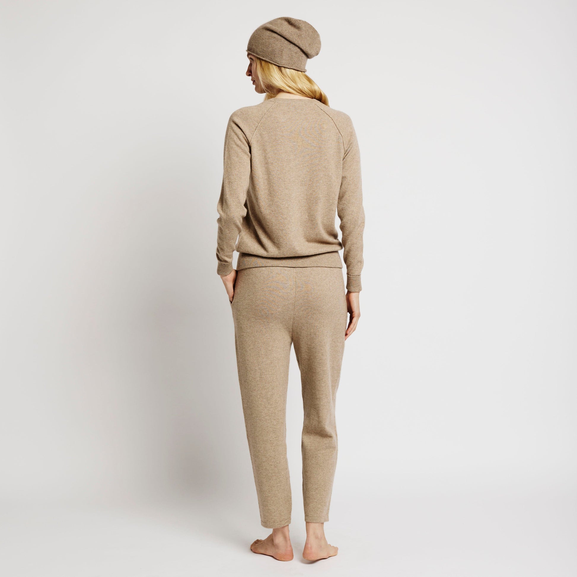 Alabaste Cashmere Joggers in oatmeal beige, 100% Mongolian cashmere, tapered leg with flat knit drawcord and ribbed cuffs, modeled back view.