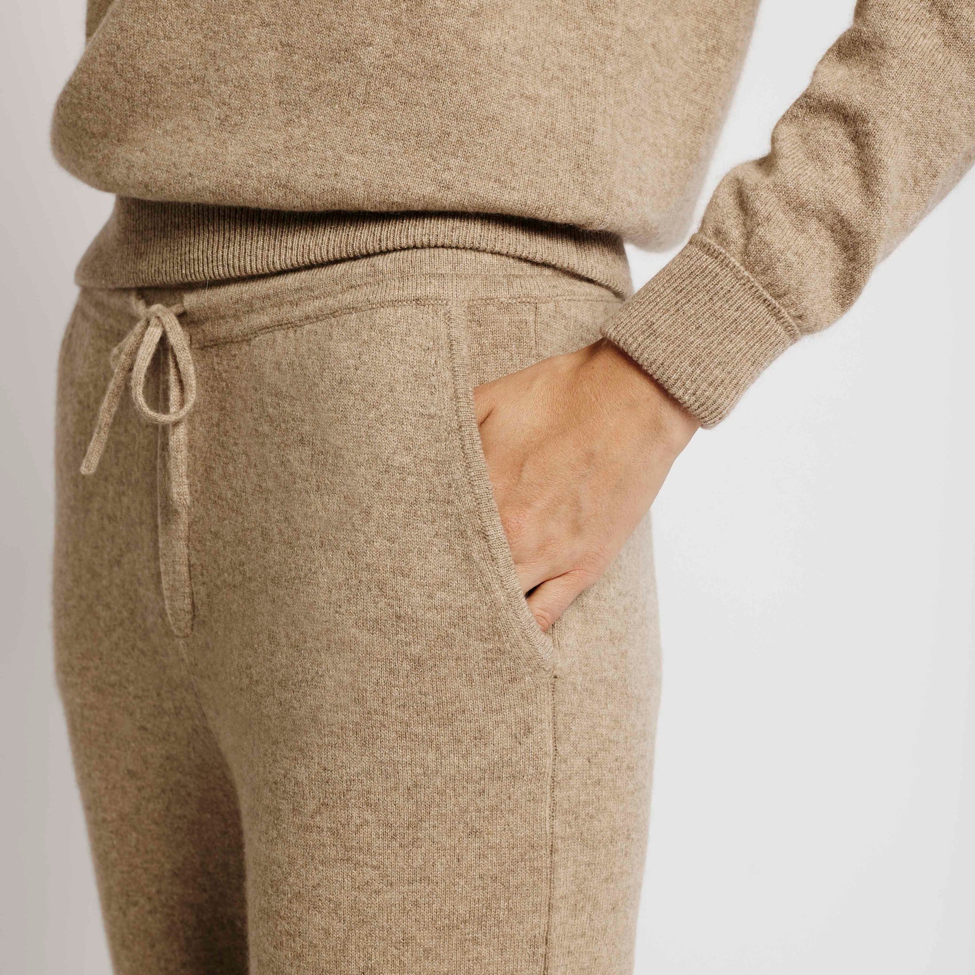 Close-up of Alabaste Cashmere Joggers in oatmeal beige, showing flat knit drawcord and ribbed waistband detail.